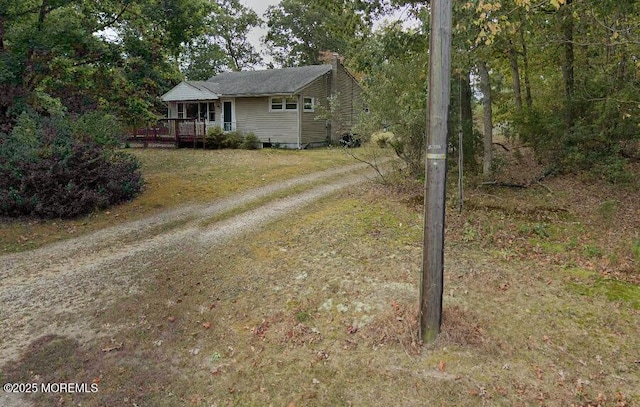 view of front of home featuring driveway and a wooden deck