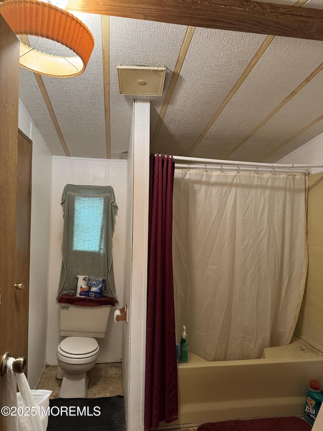 full bath featuring a textured ceiling, shower / bath combination with curtain, and toilet