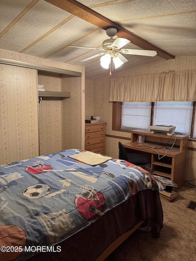 carpeted bedroom with wallpapered walls, a ceiling fan, visible vents, and a closet