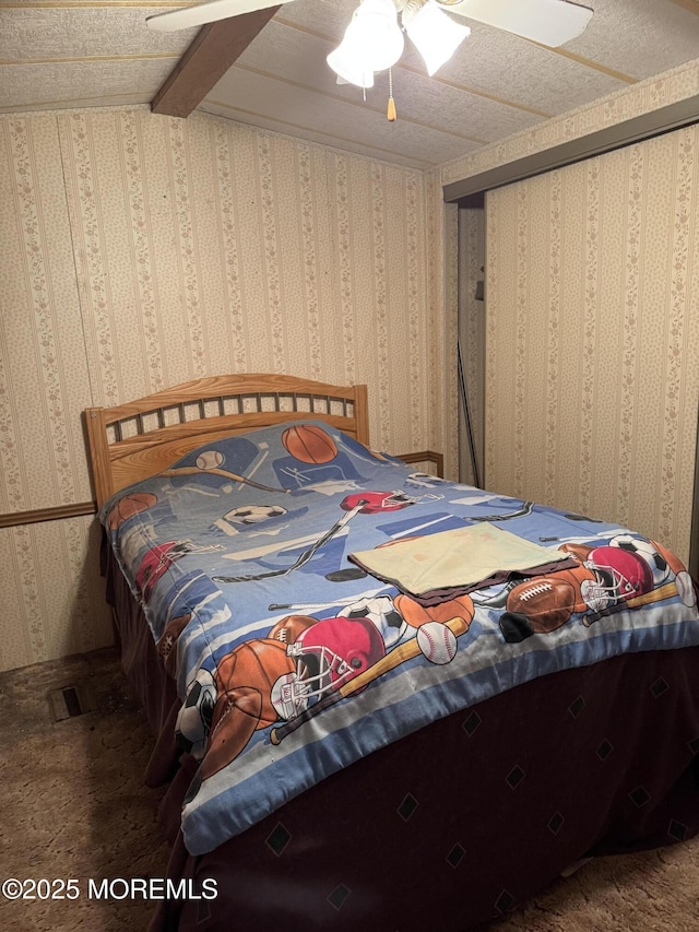 carpeted bedroom with a ceiling fan and wallpapered walls