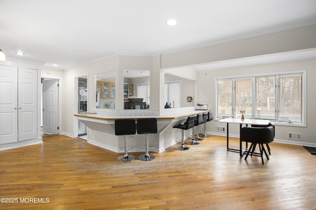 1759 Todd Rd, Toms River, NJ 08755 - kitchen featuring light wood-style flooring, crown molding, a breakfast bar, baseboards, and recessed lighting