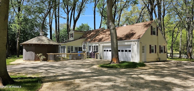 view of front of property featuring a deck, driveway, and a garage