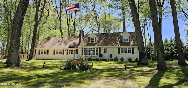 view of front of house with a chimney and a front lawn