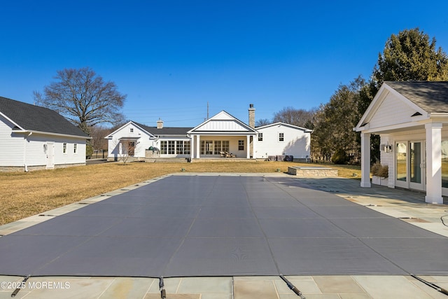 view of swimming pool with a patio, french doors, and a lawn