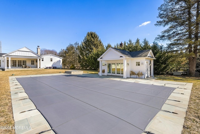 view of pool featuring a yard, an outbuilding, a patio, and french doors