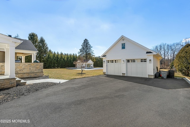 exterior space with a garage, a yard, and an outbuilding