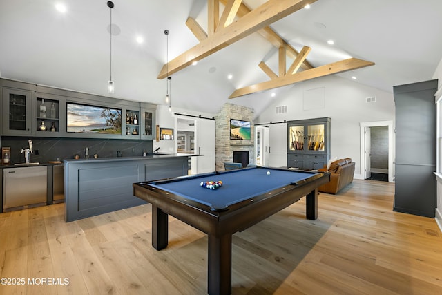 playroom featuring light wood-style floors, billiards, high vaulted ceiling, and a barn door