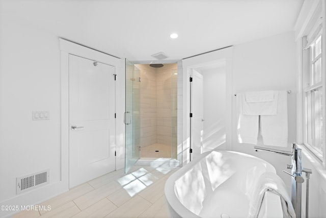 full bath featuring a soaking tub, visible vents, and a shower stall