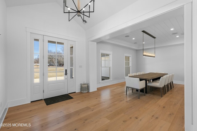 dining space with vaulted ceiling, recessed lighting, light wood-type flooring, and an inviting chandelier