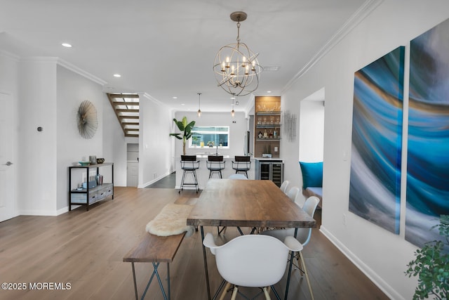 dining room featuring a chandelier, recessed lighting, indoor bar, ornamental molding, and dark wood-style floors