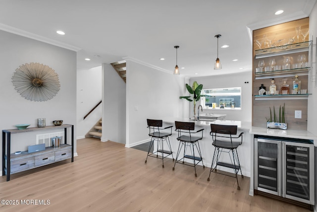 bar with wine cooler, a dry bar, stairway, light wood-style floors, and a sink