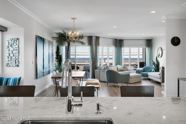 dining room with baseboards, ornamental molding, wood finished floors, an inviting chandelier, and recessed lighting