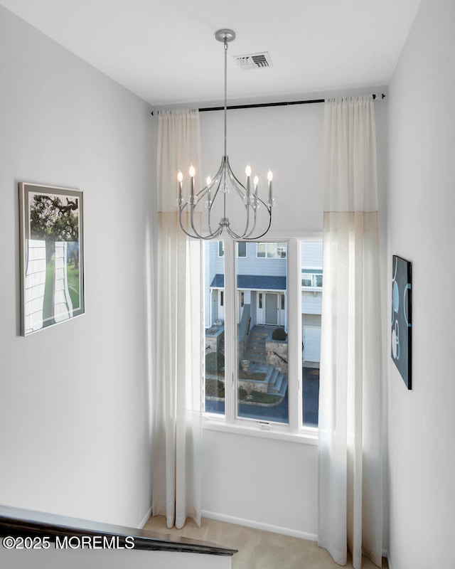 dining area featuring visible vents, a chandelier, baseboards, and light colored carpet