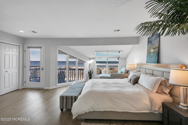 bedroom featuring access to outside, visible vents, baseboards, and wood finished floors