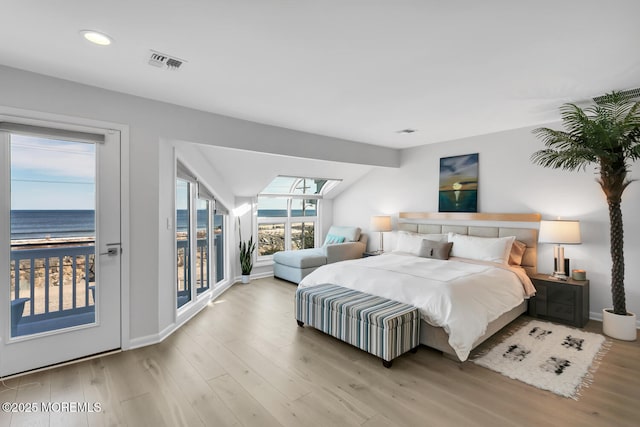 bedroom featuring access to exterior, visible vents, vaulted ceiling, wood finished floors, and baseboards