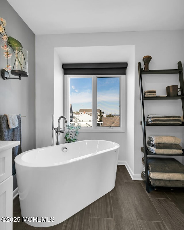 bathroom featuring a freestanding bath and baseboards