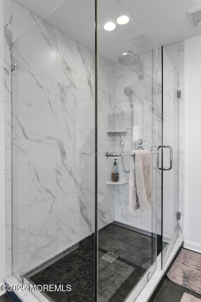 full bath with visible vents and a marble finish shower