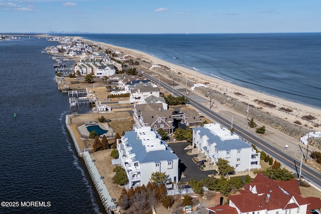 birds eye view of property featuring a water view and a beach view