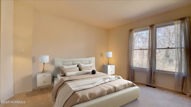 carpeted bedroom with visible vents and baseboards