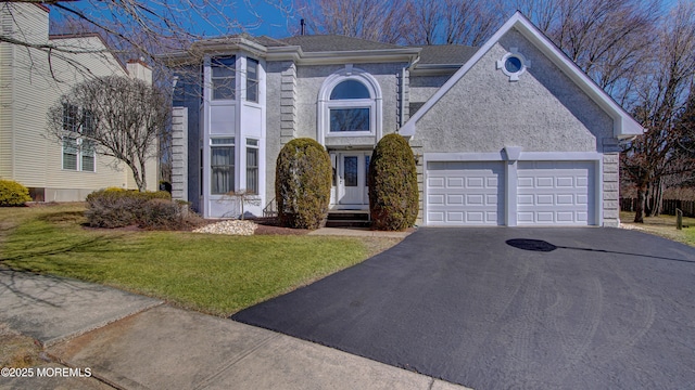 view of front of home with aphalt driveway, an attached garage, and a front lawn