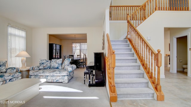 staircase featuring a high ceiling and a notable chandelier