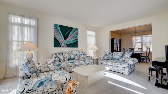 carpeted living room with a notable chandelier