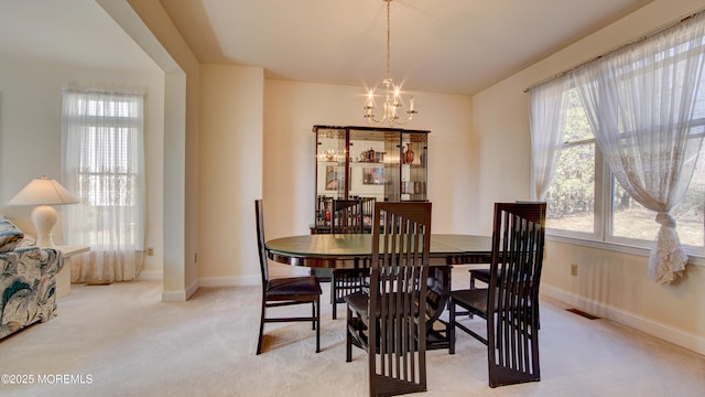 dining space with light carpet, a healthy amount of sunlight, and visible vents