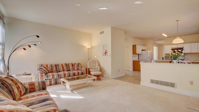 living room featuring light carpet, visible vents, and baseboards