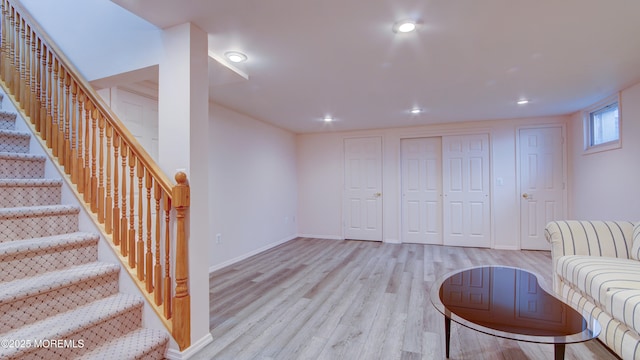 living area featuring baseboards, wood finished floors, stairs, and recessed lighting