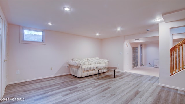 unfurnished living room with stairs, light wood finished floors, baseboards, and recessed lighting