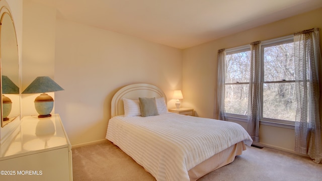 bedroom featuring light carpet, visible vents, and baseboards