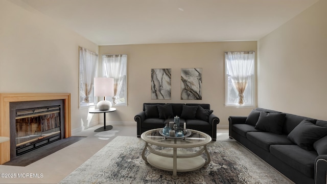 living area featuring a fireplace with flush hearth and baseboards