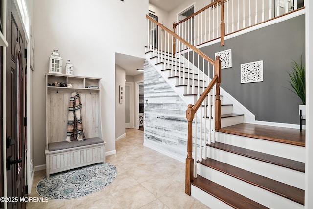 interior space featuring baseboards and a towering ceiling