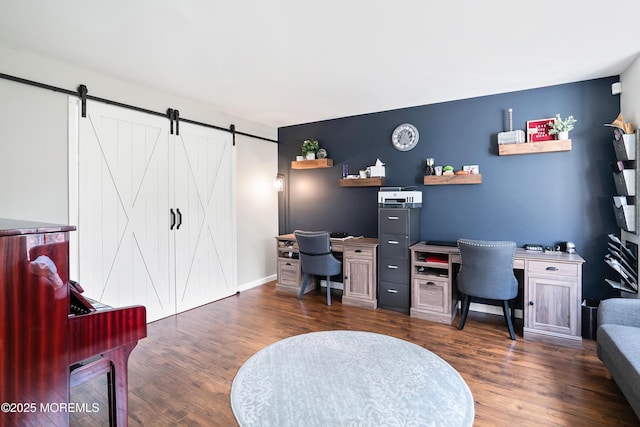 home office with dark wood finished floors, a barn door, and baseboards