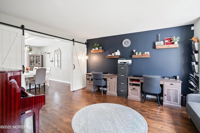 office with a barn door, baseboards, and dark wood finished floors