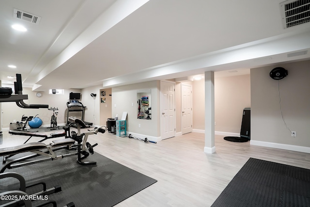 workout room featuring light wood-style flooring, baseboards, and visible vents