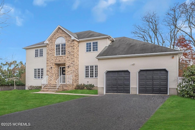 view of front of house featuring a front lawn, an attached garage, and aphalt driveway