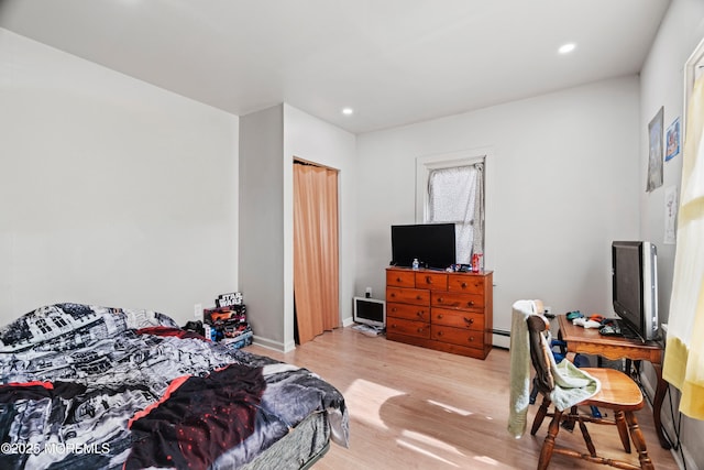 bedroom with a baseboard heating unit, recessed lighting, and wood finished floors