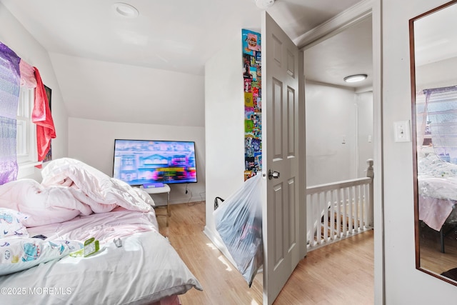 bedroom featuring lofted ceiling and light wood-style flooring