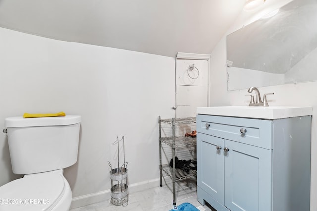 half bathroom with marble finish floor, baseboards, vanity, and toilet