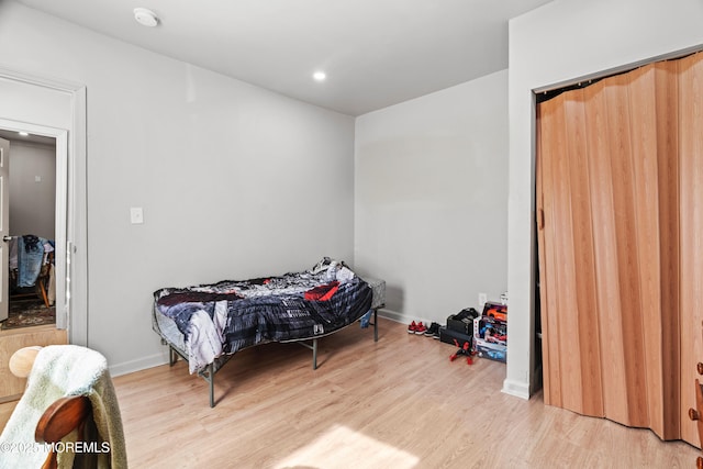 bedroom with baseboards, wood finished floors, and recessed lighting