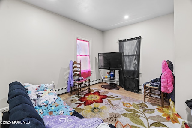 living area featuring a baseboard heating unit and wood finished floors