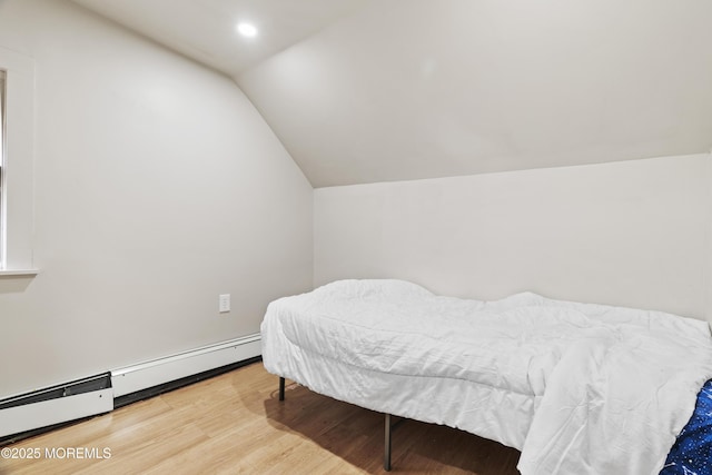 bedroom featuring a baseboard heating unit, recessed lighting, vaulted ceiling, and wood finished floors