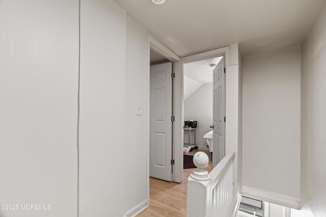 hall featuring light wood finished floors and baseboards