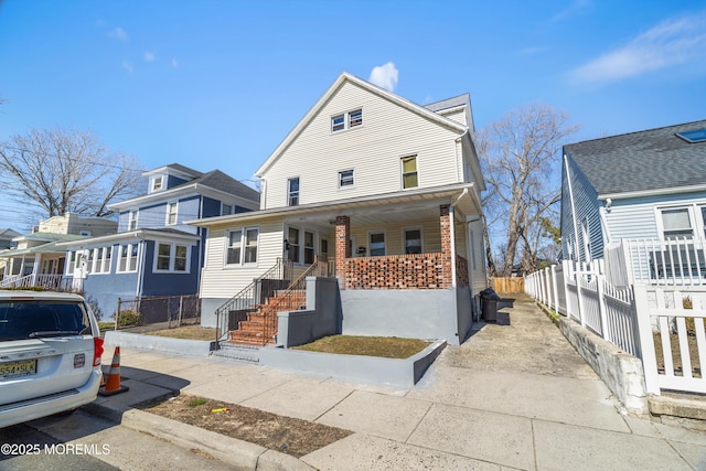 view of front of house with covered porch and fence