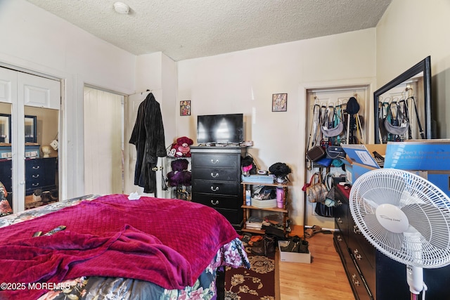 bedroom with a textured ceiling and wood finished floors