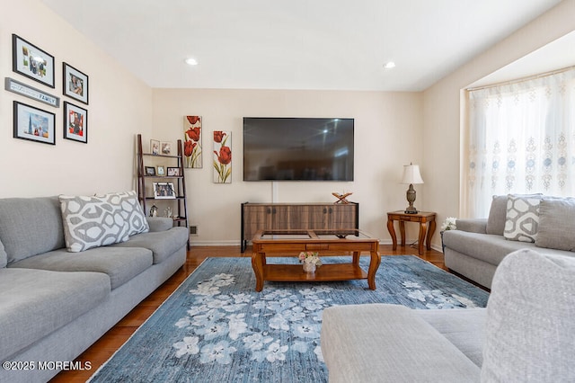 living room featuring baseboards, wood finished floors, and recessed lighting