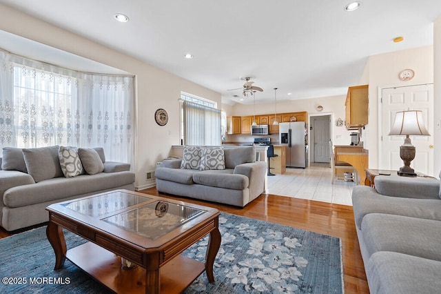 living room featuring ceiling fan, light wood finished floors, and recessed lighting