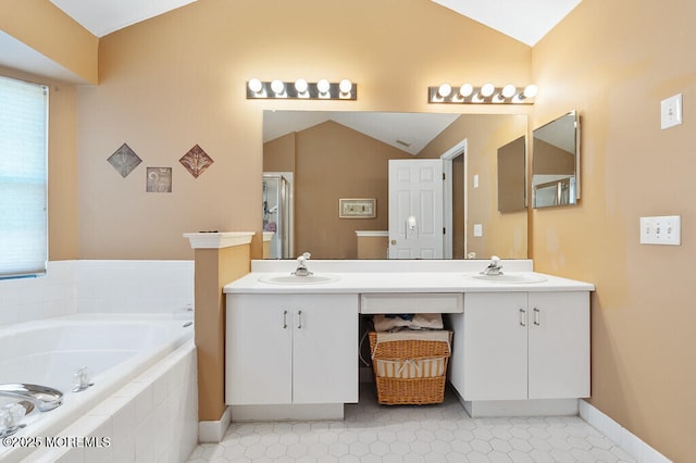 full bathroom with lofted ceiling, double vanity, a sink, and a garden tub