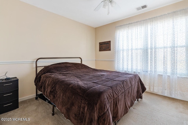 carpeted bedroom featuring ceiling fan, visible vents, and baseboards